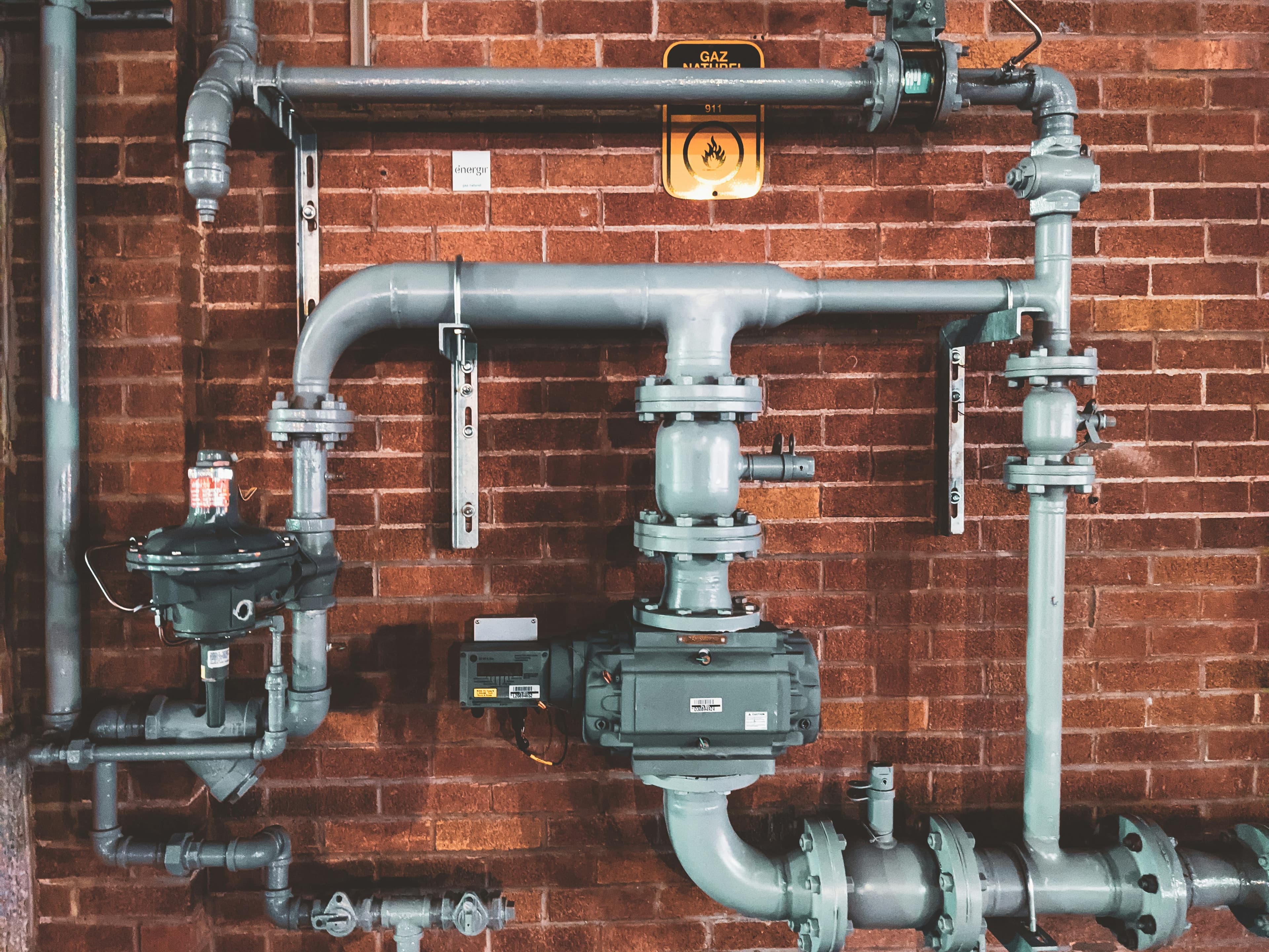 Assembled pipe fittings and valves on a brick wall